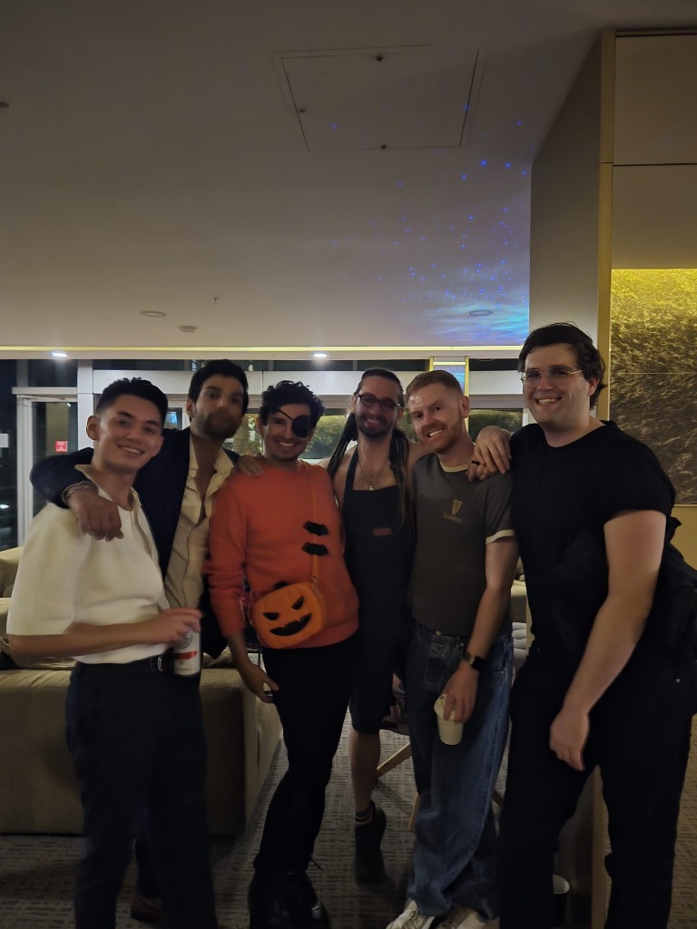 Six friends standing together smiling at the party