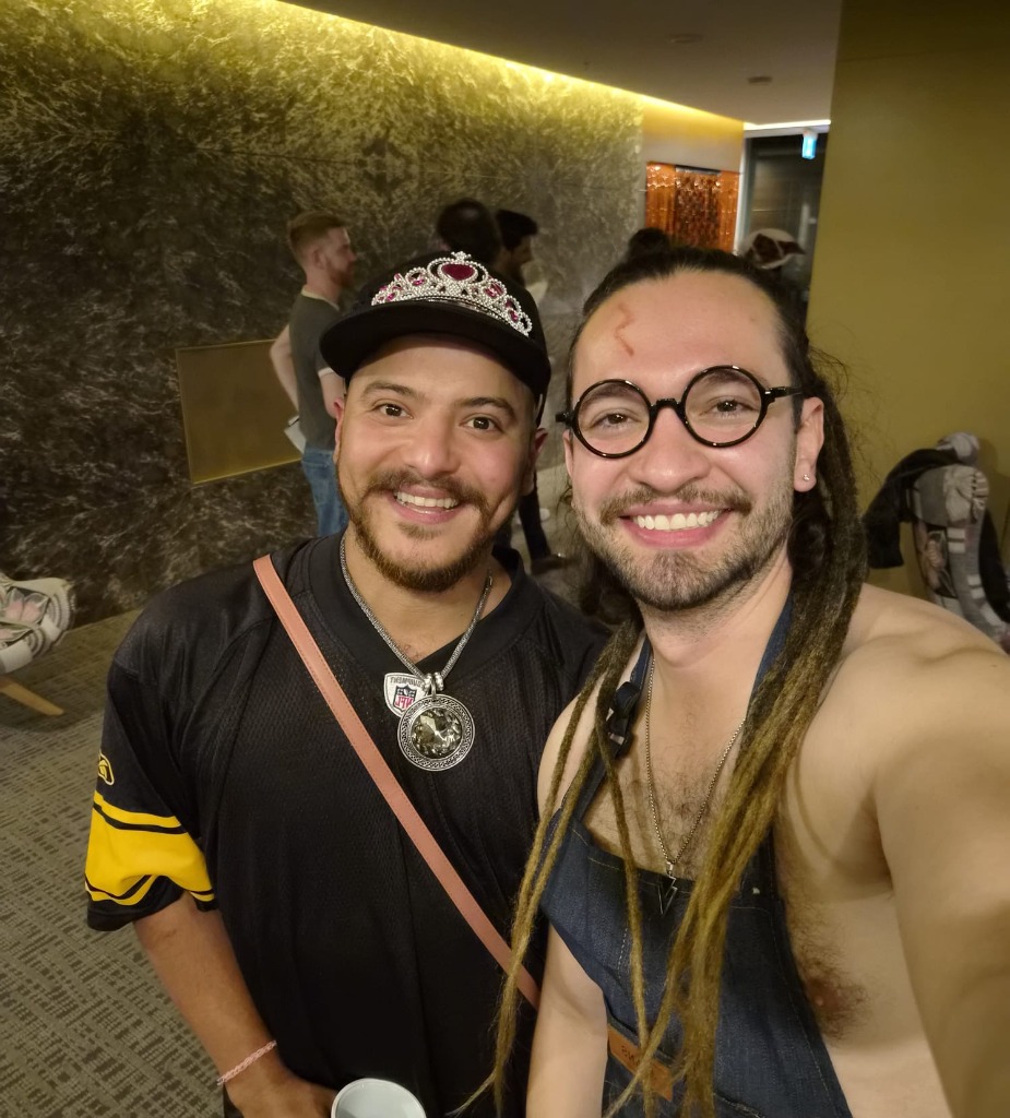 Close-up of two friends smiling in tiara NFL jersey and glasses