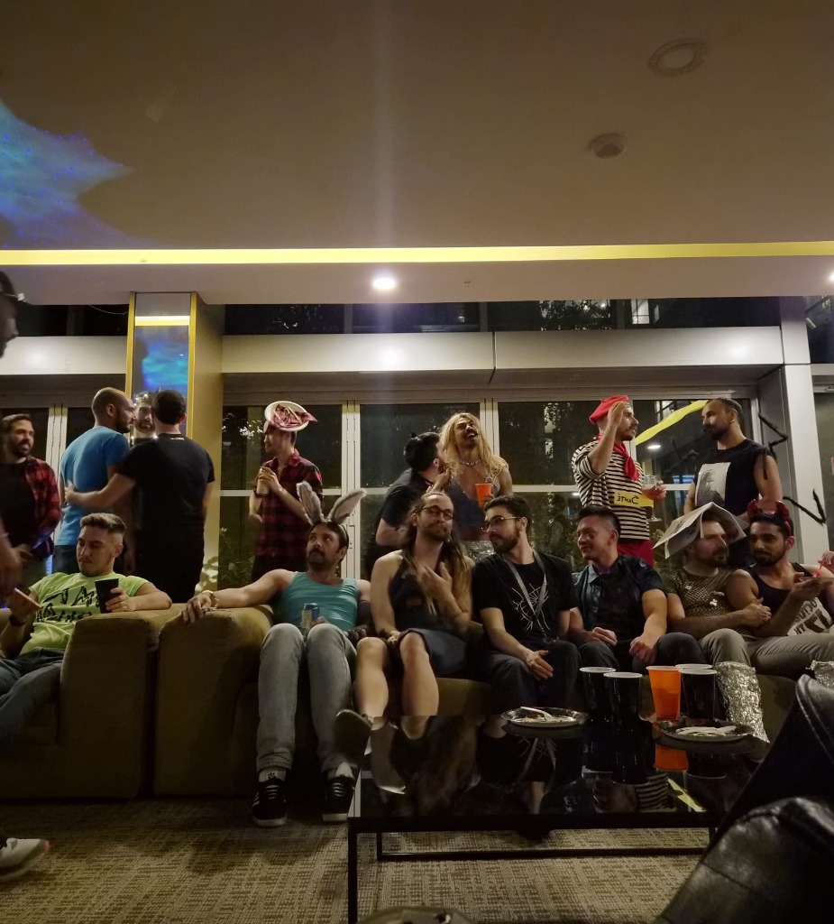 Candid wide shot of friends chatting and laughing on the lounge sofa